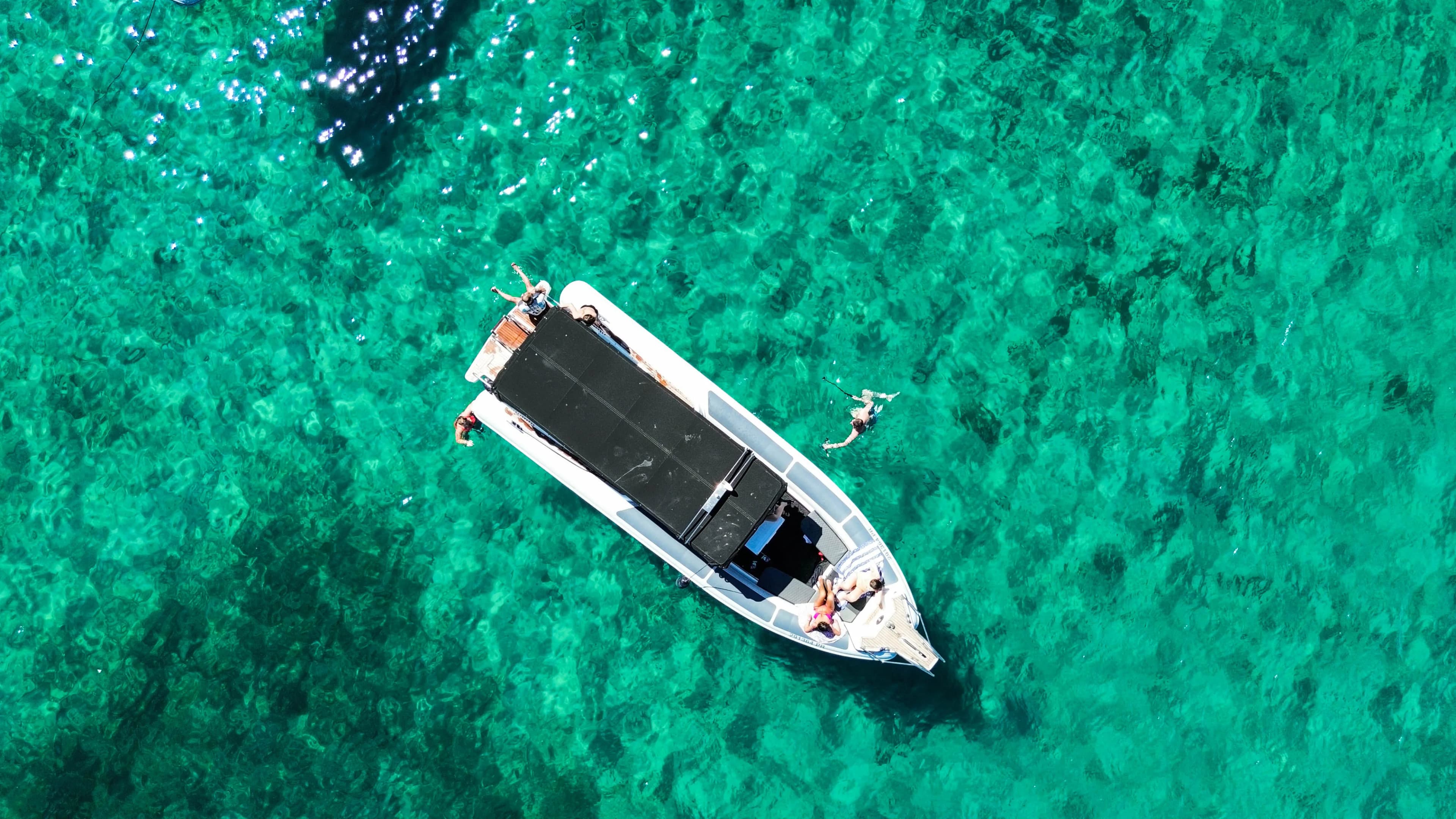 Boat seen from above on turquoise sea